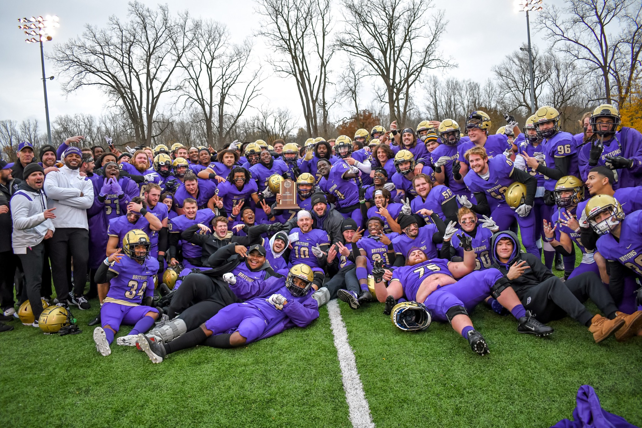 Albion football team gathered on the field in celebration after a championship
