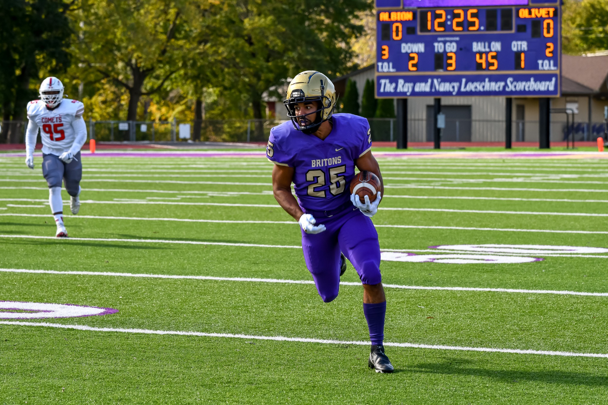Albion football player in purple running with the ball in open field