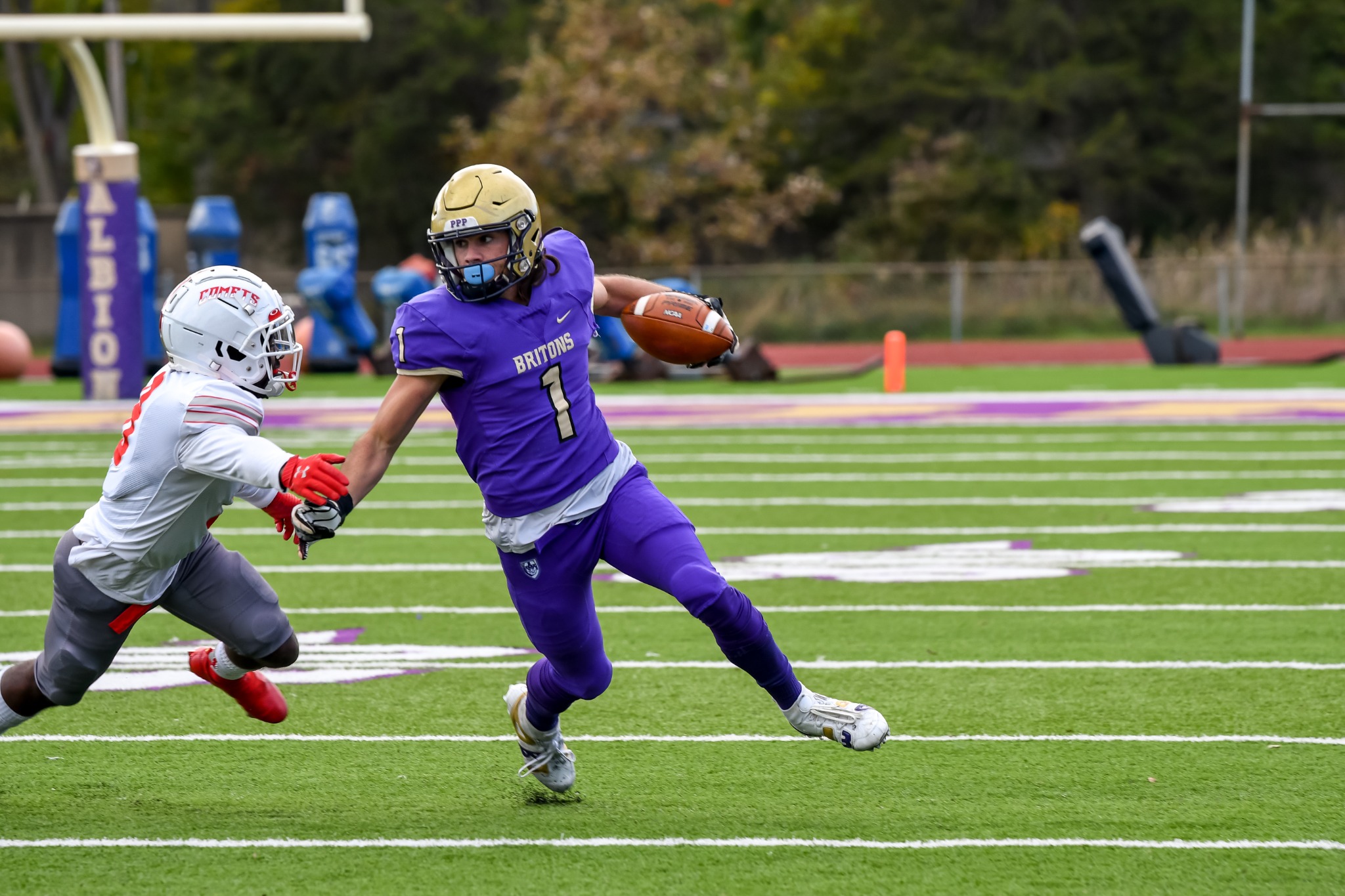 Albion football player stiff-arming a defender while carrying the ball