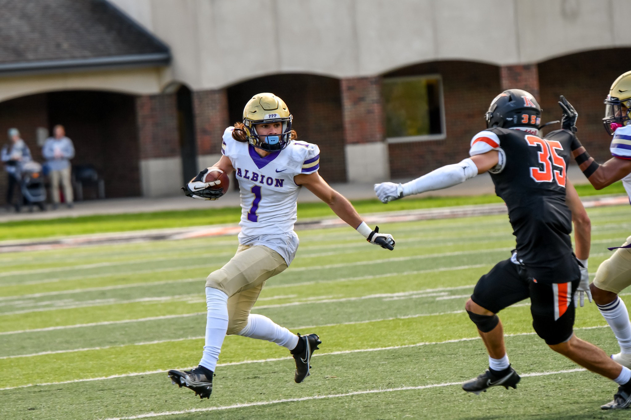 Albion football player carrying the ball toward a defender during live action