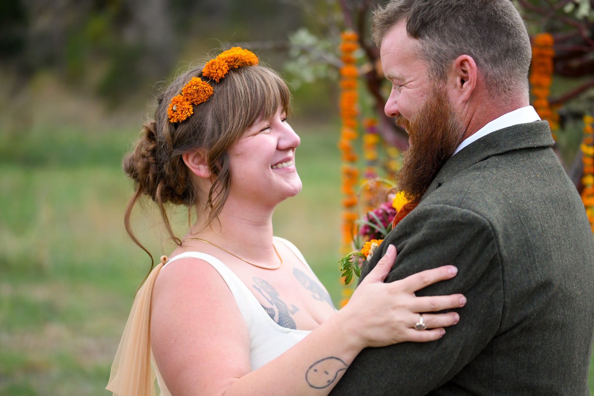 Newlywed couple smiling at each other outdoors